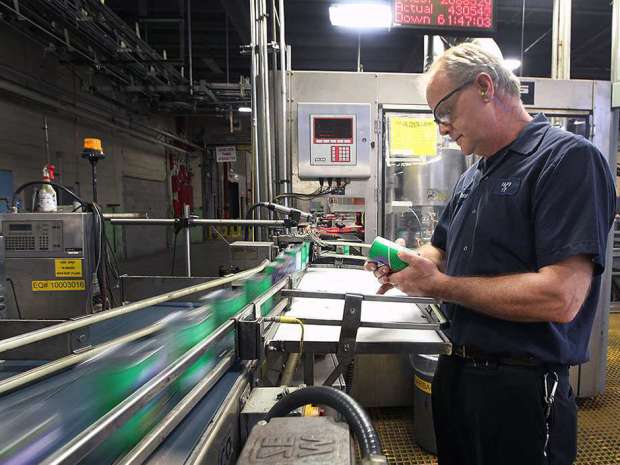 Highbury Canco employee Nathan Cook checks the label on a can of beans at the Leamington plant.