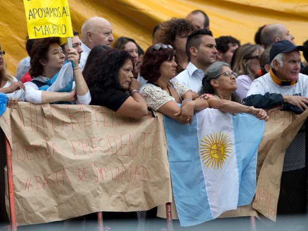 Supporters of Argentina's President Mauricio Macri stand outside the National Congress as the President opens the 2016 session of Congress for his annual State of the Nation address, in Buenos Aires, Argentina, Tuesday, March 1, 2016. Argentina, like many other Latin American nations, has been hit by the collapse in commodity prices.