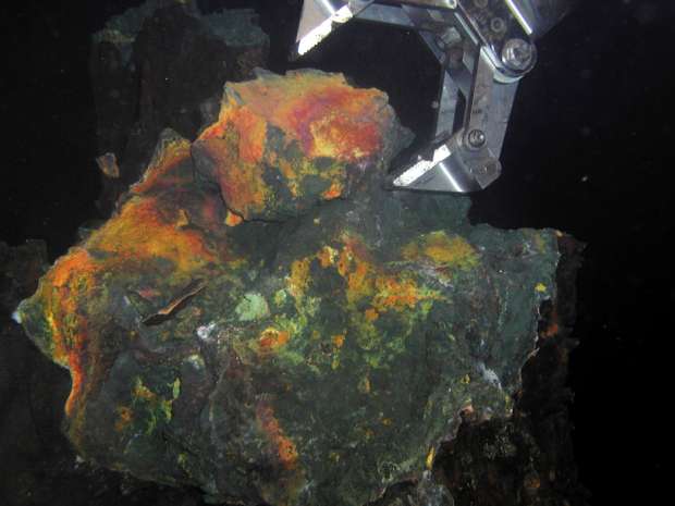 A "hand" of a remote operated vehicle picks up a piece of rich gold-copper ore recovered from the seafloor in 1,700m of water in the Bismarck Sea offshore Papua New Guinea.