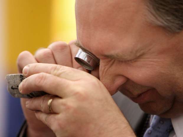 A conference-goer surveys a sample in Toronto at the annual PDAC Conference.