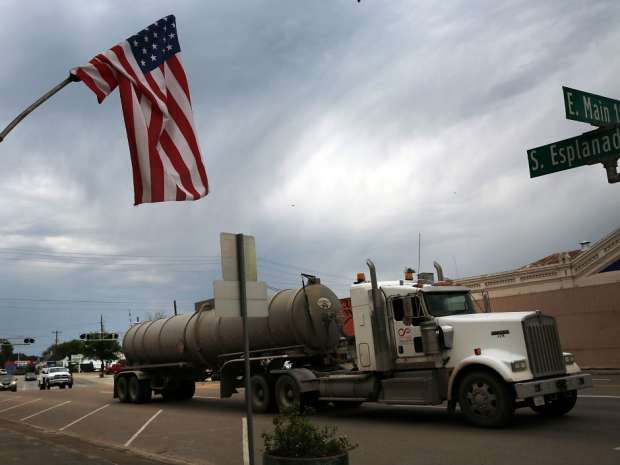 Trucks serving the oil industry pass through the town of Cuero, Texas.