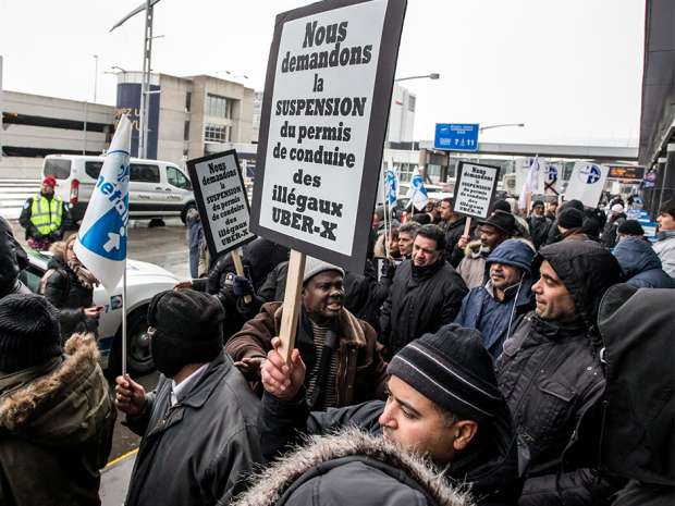 Montreal's taxi drivers stand in front of the P.E. Trudeau Airport to protest against Uber, on Wednesday.